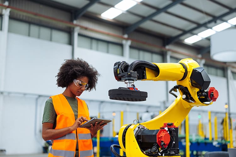 manufacturing woman with tablet and robot arm